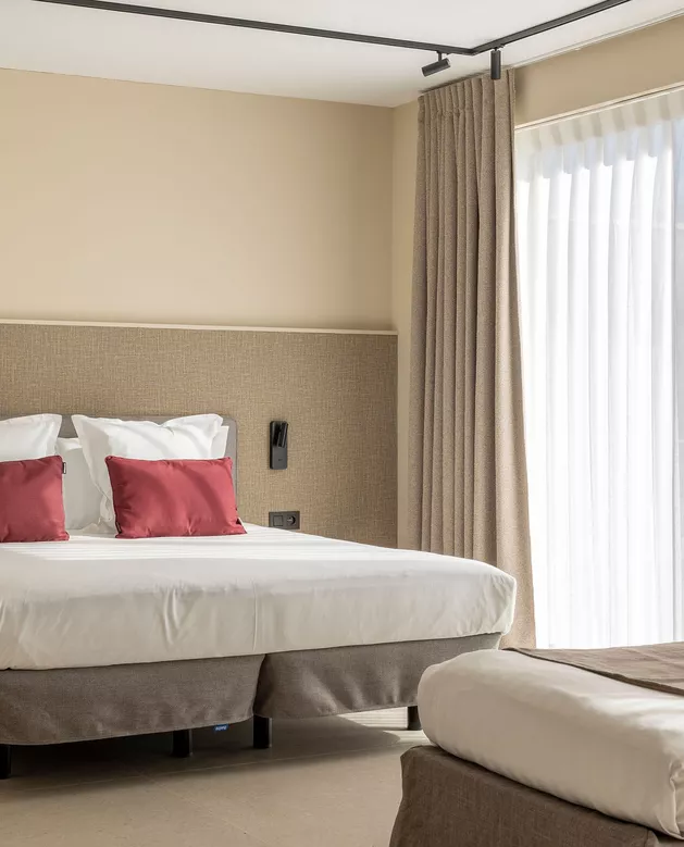 Hotelkamer met raamdecoratie, bedden en bedlinnen van Altex